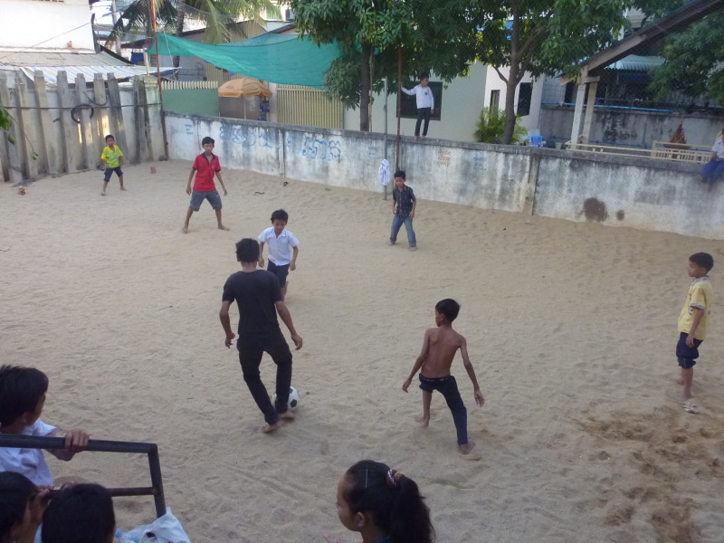 休憩時間に校庭でサッカーするカンボジアの子どもたち